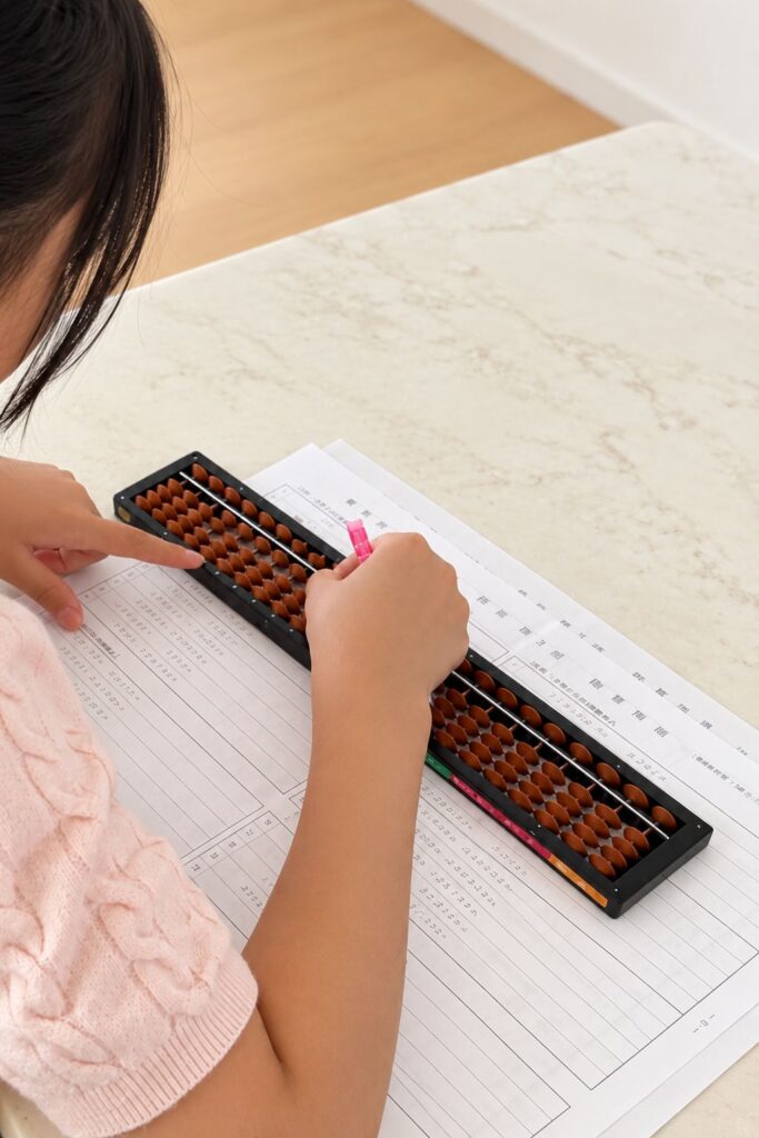 小学生が家庭でそろばんの問題に取り組んでいる様子